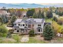 Two-story home with solar panels, inviting porch and mature trees surrounded by mountain views at 8924 Prairie Knoll Dr, Longmont, CO 80503