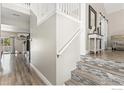 Bright hallway featuring stylish tile stairs, hardwood floors, and neutral color scheme at 9930 Cascade St, Firestone, CO 80504