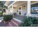 Inviting front porch with classic columns, detailed windows, and cozy seating area at 1013 4Th Ave, Longmont, CO 80501