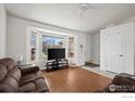 Bright living room with hardwood floors, large windows, and a cozy seating area at 11296 Daisy Ct, Firestone, CO 80504