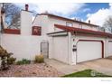 Two-story exterior showing a garage, gated courtyard, red roof, and landscaped garden at 1321 Madero St, Broomfield, CO 80020