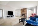 Spacious living area featuring a stone fireplace, ample seating, and sliding glass door at 1321 Madero St, Broomfield, CO 80020