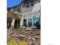 Inviting exterior view showing a patio with large window and stylish stone accents at 1831 Kalel Ln, Louisville, CO 80027