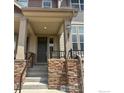 Charming front entrance with stone accents, covered porch, and well-maintained stairs at 1831 Kalel Ln, Louisville, CO 80027