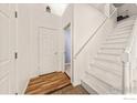 Bright entryway featuring wood-look floors, white walls, and a staircase at 21562 E 47Th Ave, Denver, CO 80249