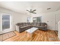 Living room with a large sectional sofa, bright lighting, and wood floors at 21562 E 47Th Ave, Denver, CO 80249