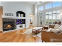 Bright living room with hardwood floors, fireplace, and large windows for natural light at 2210 Calais Dr # B, Longmont, CO 80504