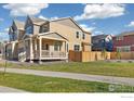 Side view of a charming home featuring a covered porch and a well-maintained lawn at 2260 Crescent Cir, Erie, CO 80026