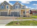 Inviting two-story home with a brick driveway, covered porch, and a well-maintained lawn at 2260 Crescent Cir, Erie, CO 80026
