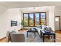 Bright living room with large windows offering scenic views and hardwood floors at 2499 Powderhorn Ln, Boulder, CO 80305