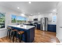 Gourmet eat-in kitchen featuring white cabinets, navy blue island, stainless steel appliances, and beautiful forest views at 251 Ridgeview Ln, Boulder, CO 80302