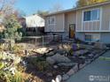 Landscaped front yard with rock garden, decorative features, and partial fencing at 266 Wooster Ave, Firestone, CO 80520