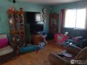 Cozy living room with hardwood floors, furniture, and a large window at 266 Wooster Ave, Firestone, CO 80520