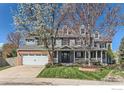 Charming two-story home featuring a welcoming front porch and well-manicured lawn on a sunny day at 2862 Flint Ct, Superior, CO 80027