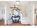 Bright foyer with white walls, wooden floors, a decorative table, and staircase at 2935 19Th St, Boulder, CO 80304