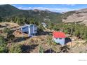 Mountain home with a detached garage with stairs nestled in a lush green mountain landscape at 319 Camino Bosque, Boulder, CO 80302