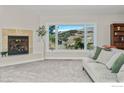 Cozy living room with a stone fireplace, neutral sofa, and a large window offering scenic mountain views at 319 Camino Bosque, Boulder, CO 80302