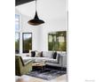 Bright living room featuring a modern sectional sofa, stylish rug, and expansive windows with views at 319 S Peak Rd, Boulder, CO 80302