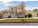 Inviting yellow home with a brick-lined flowerbed and a lush green lawn at 3530 Willow Rd, Frederick, CO 80504