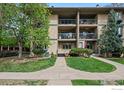 Inviting condo complex with private balcony, beautiful green spaces, and well-manicured lawn at 400 Emery St # 104, Longmont, CO 80501