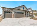 New construction home with stone accents, a covered front porch, a three-car garage and a concrete driveway at 4316 Gypsum Ave, Mead, CO 80504