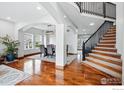 Open-concept dining area showcasing hardwood floors, a modern chandelier, and staircase to upper level at 505 Saint Andrews Dr, Longmont, CO 80504