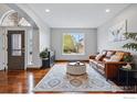 Bright living room with a leather couch, area rug, and modern decor, illuminated by natural light at 505 Saint Andrews Dr, Longmont, CO 80504