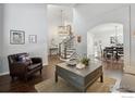 Spacious open-concept living room with staircase, hardwood floors, and elegant decor at 520 Campo Way, Superior, CO 80027