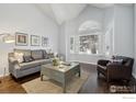 Inviting living room with vaulted ceilings, shutters, and a view of the snowy outdoors at 520 Campo Way, Superior, CO 80027