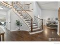 Elegant staircase with wrought iron details, hardwood floors, and a view into the living room at 520 Campo Way, Superior, CO 80027