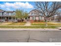Charming two-story home with a brick foundation, well-maintained lawn, and mature trees at 5355 Killdeer St, Brighton, CO 80601
