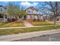 Charming two-story home with a brick foundation, lush lawn, and mature trees at 5355 Killdeer St, Brighton, CO 80601