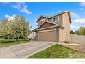 Well-maintained home showcasing a two-car garage, siding, and manicured lawn at 5452 Rustic Ave, Firestone, CO 80504