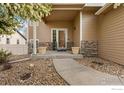 Inviting front porch with stone accents, manicured landscaping, and a welcoming entrance at 5452 Rustic Ave, Firestone, CO 80504