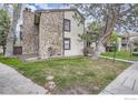 Close up of condo featuring a combination of neutral siding and stone, complemented by lush green lawns at 7720 W 87Th Dr # N, Arvada, CO 80005