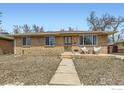 Attractive brick home featuring a well-manicured front yard and inviting front porch seating at 7950 Maria St, Westminster, CO 80030