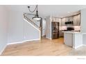 Open-concept living room with hardwood floors, staircase, and a view of the modern kitchen at 827 Snowberry St, Longmont, CO 80503
