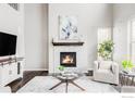 Bright living room with a fireplace, large windows, and stylish decor at 8346 Wilkerson Ct, Arvada, CO 80007