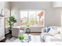 Living room with modern gray sofas, large window, and an area rug at 8346 Wilkerson Ct, Arvada, CO 80007