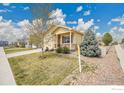Well-maintained home with green lawn and gravel, showcasing the property's curb appeal and landscaping under a partly cloudy sky at 11166 Charles St, Firestone, CO 80504