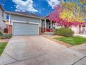 Charming home with a two-car garage, well-maintained lawn, and colorful tree at 12948 E 106Th Way, Commerce City, CO 80022