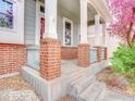 Close-up of porch featuring brick columns, decorative railings, and concrete steps at 12948 E 106Th Way, Commerce City, CO 80022