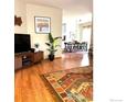 Inviting living room featuring hardwood floors and an open floor plan connecting to the dining area at 13873 Legend Way # 103, Broomfield, CO 80023