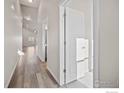 Bright hallway with high ceilings, wood floors, and natural light pouring through open doors at 196 Bird Way, Lochbuie, CO 80603