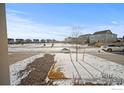 A wintery street view of a quiet neighborhood with snow on the ground at 196 Bird Way, Lochbuie, CO 80603