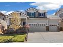 Inviting two-story house with a three-car garage, stone veneer, manicured lawn, and mature trees at 2208 Bellavista St, Castle Rock, CO 80109