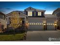 Beautiful home at twilight featuring a three-car garage, stylish exterior lighting, and attractive landscaping at 2208 Bellavista St, Castle Rock, CO 80109