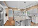 Spacious kitchen featuring white cabinets, hardwood floors, stainless steel appliances, and a center island at 2275 Schooner St, Lafayette, CO 80026