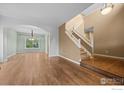 Bright and airy living room featuring hardwood floors, a staircase, and an archway leading to another room at 2275 Schooner St, Lafayette, CO 80026