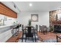 Open dining area with bar seating, table, and stone fireplace at 2727 Folsom St # 228, Boulder, CO 80304